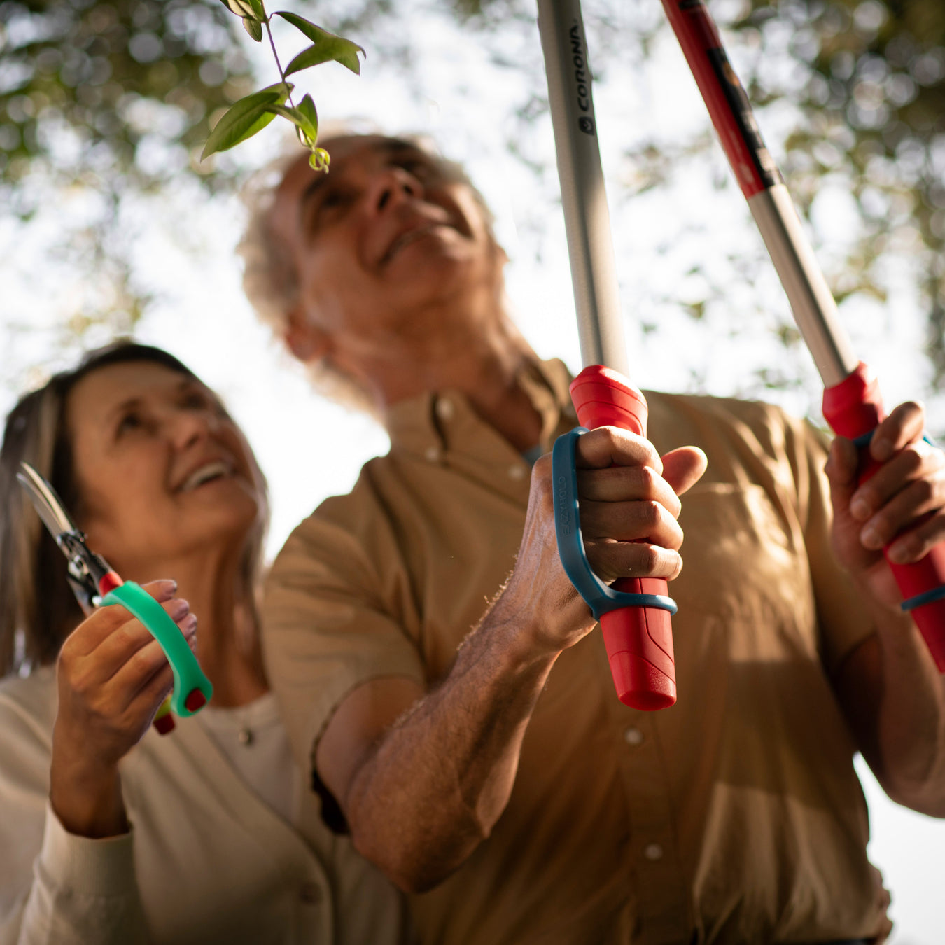 Two people holding gardening shears in a garden setting using EaZyHold products.