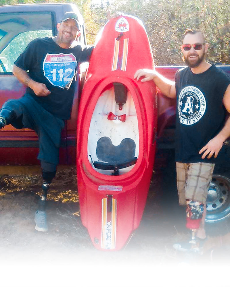 2 AMPLIFE SUPPORTERS STANDING NEXT TO A KAYAK