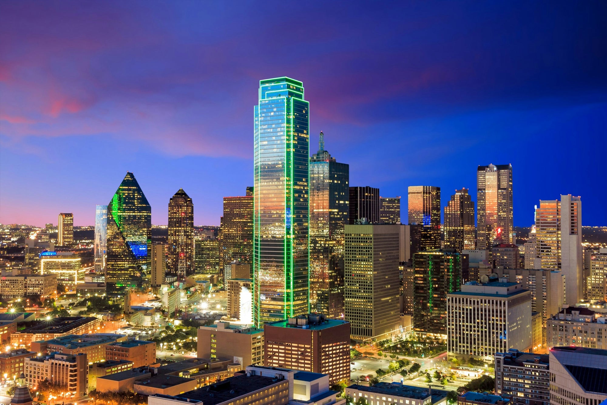 Dallas skyline with illuminated buildings at twilight.