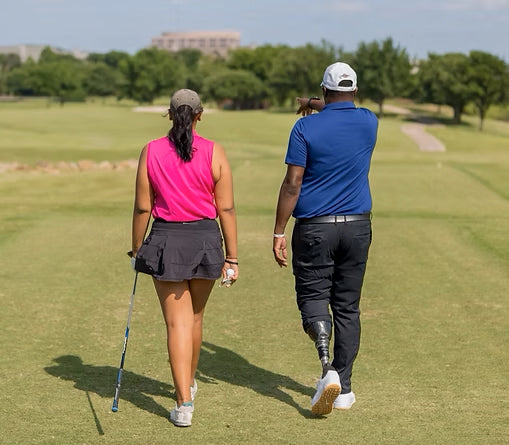 Carlos brown coaching a golfer on the course.