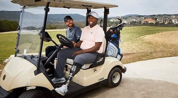 Group portrait of Carlos Brown and a fellow golfer in a golf cart.