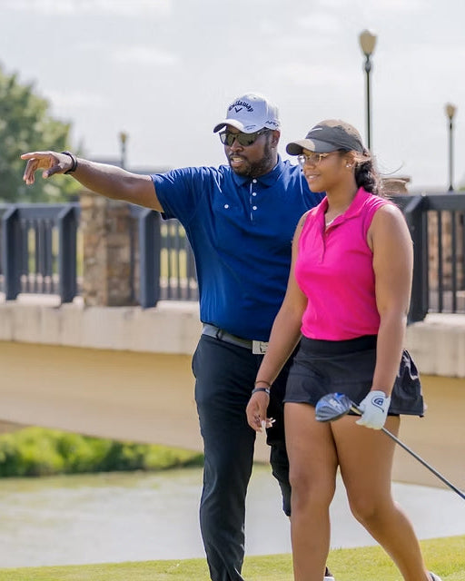 Carlos Brown walking a golfer on the course.
