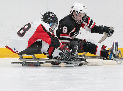 Athletes competing in sled hockey.