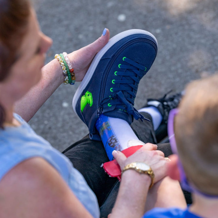 Navy/Green Light Ups BILLY Classic D|R High on model worn with a colorful AFO outdoors while resting their leg on their mother's lap