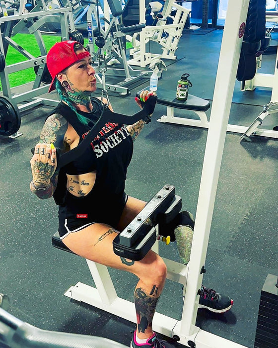 SuZanne Jacobsen performing a lat pulldown while wearing the Severed Society® Drip T-Shirt.