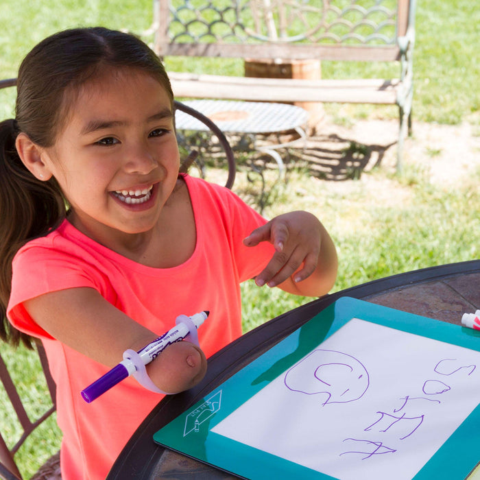Young girl writing on a portable whiteboard outdoors with an EaZyHold