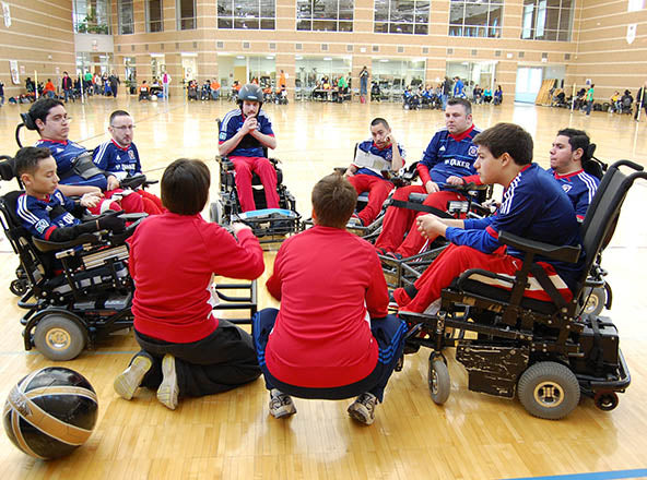Group of GLASA athletes listening to their coaches during a power soccer game.