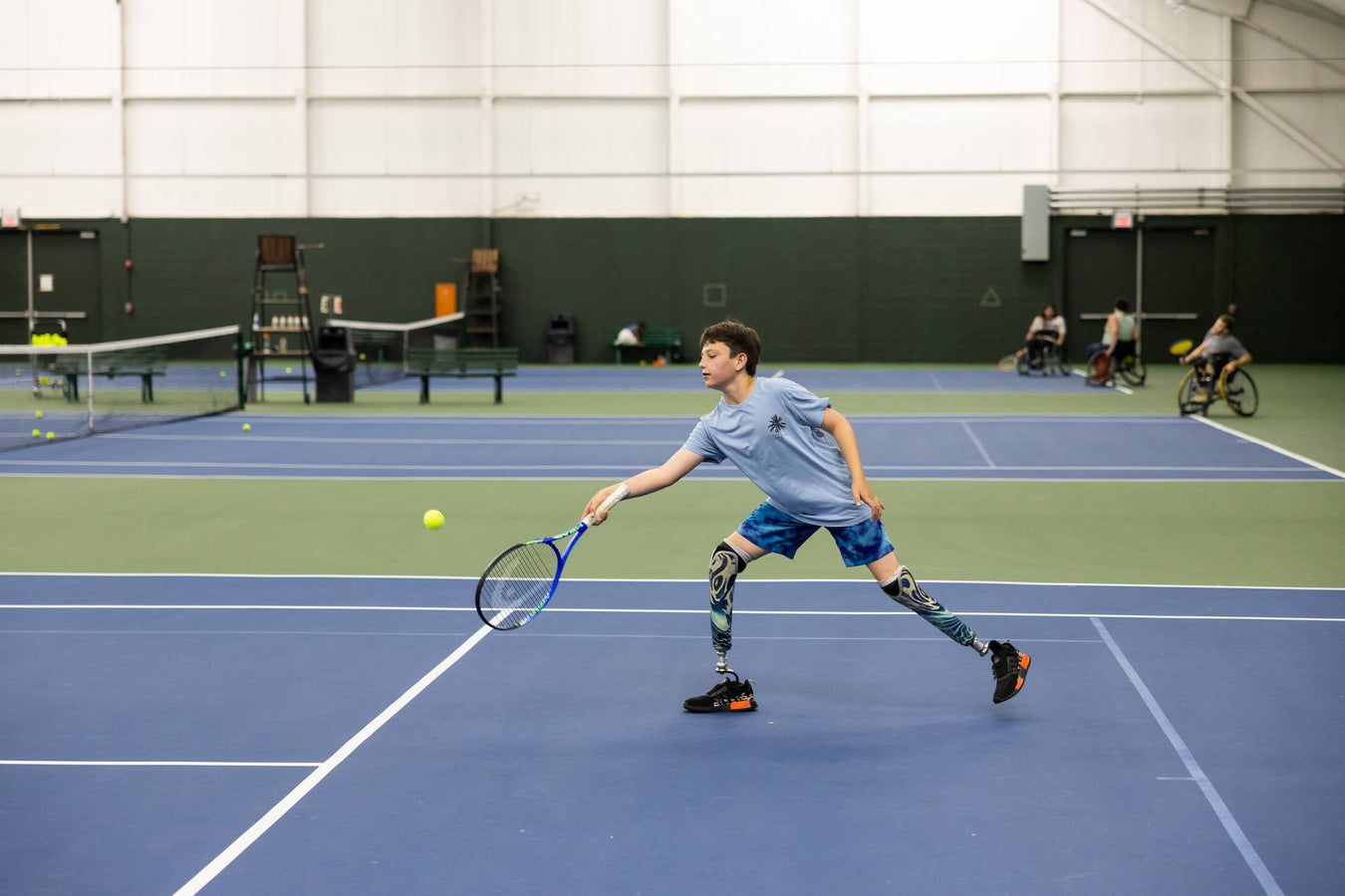 GLASA athlete with double above the knee amputations returning a tennis pass.