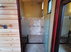 Bathroom with tiled walls, glass shower enclosure, and wooden door.