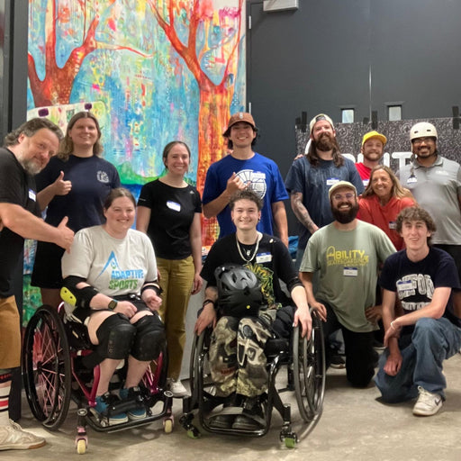 Group of Green Mountain Adaptive Sports with and without disabilities posing together in front of a colorful mural.