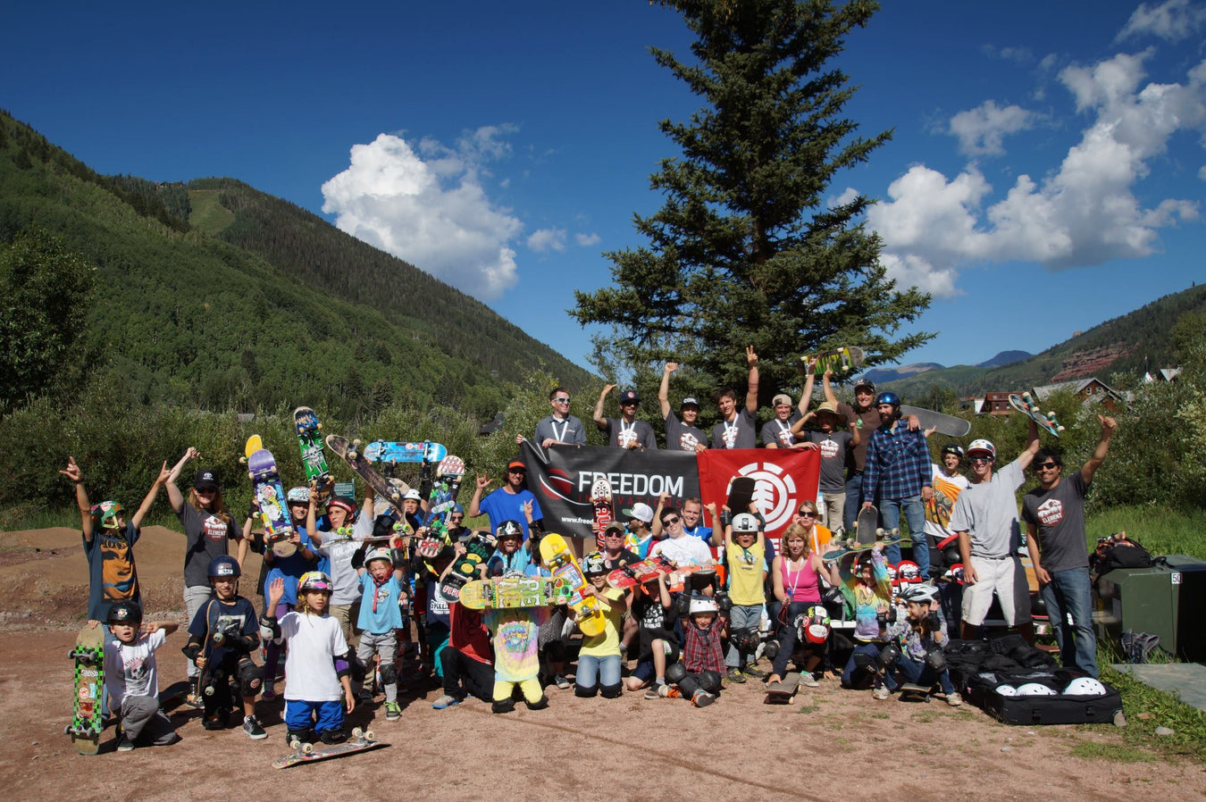 Group of people with skateboards and banners in a mountainous area
