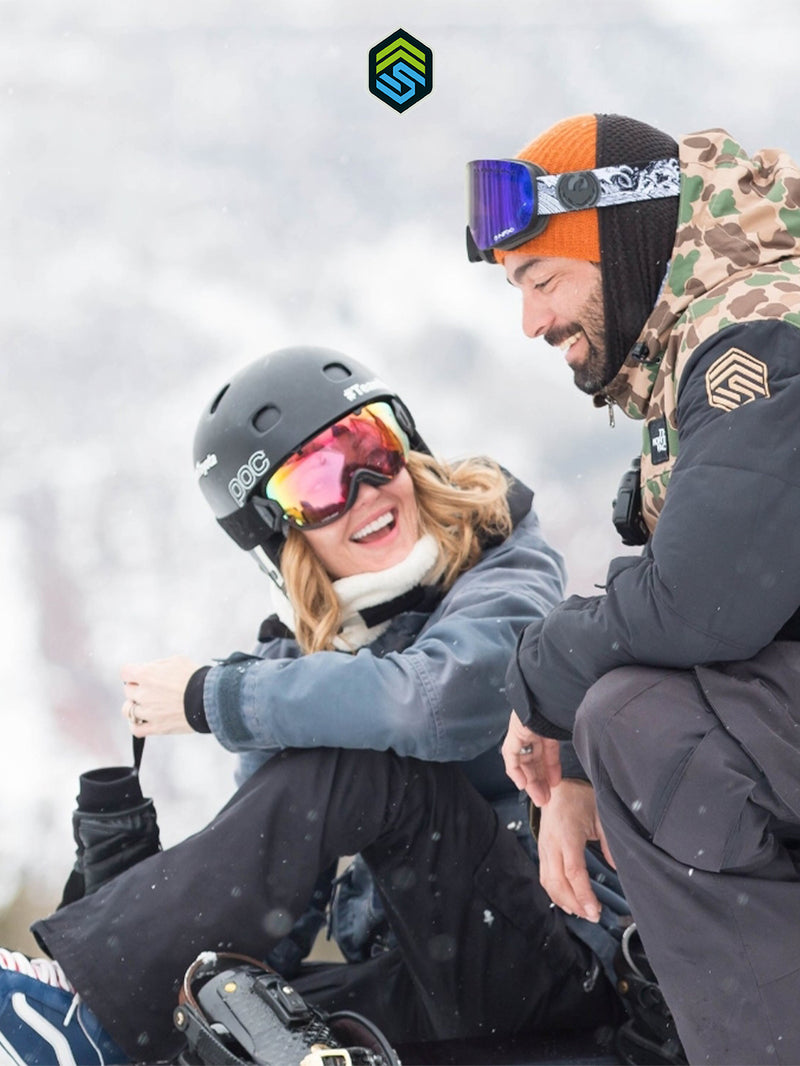 Candid photo of Adaptive Action Sports Co-Founders Amy Purdy and Daniel Gale smiling at each other with their snowboarding gear on.