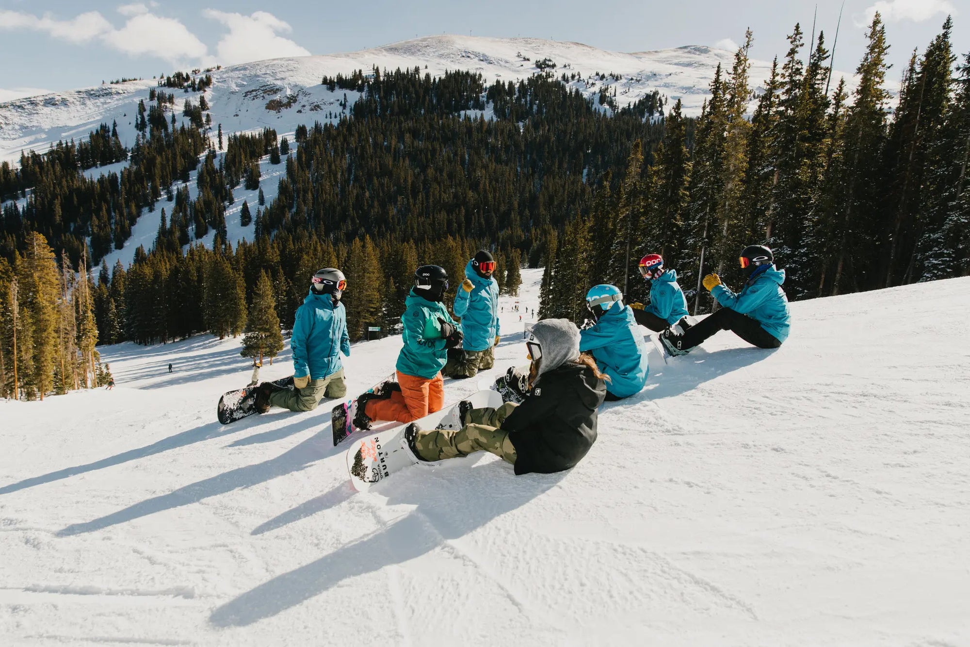 Group of Adaptive Action Sports snowboarders relaxing on the mountain.