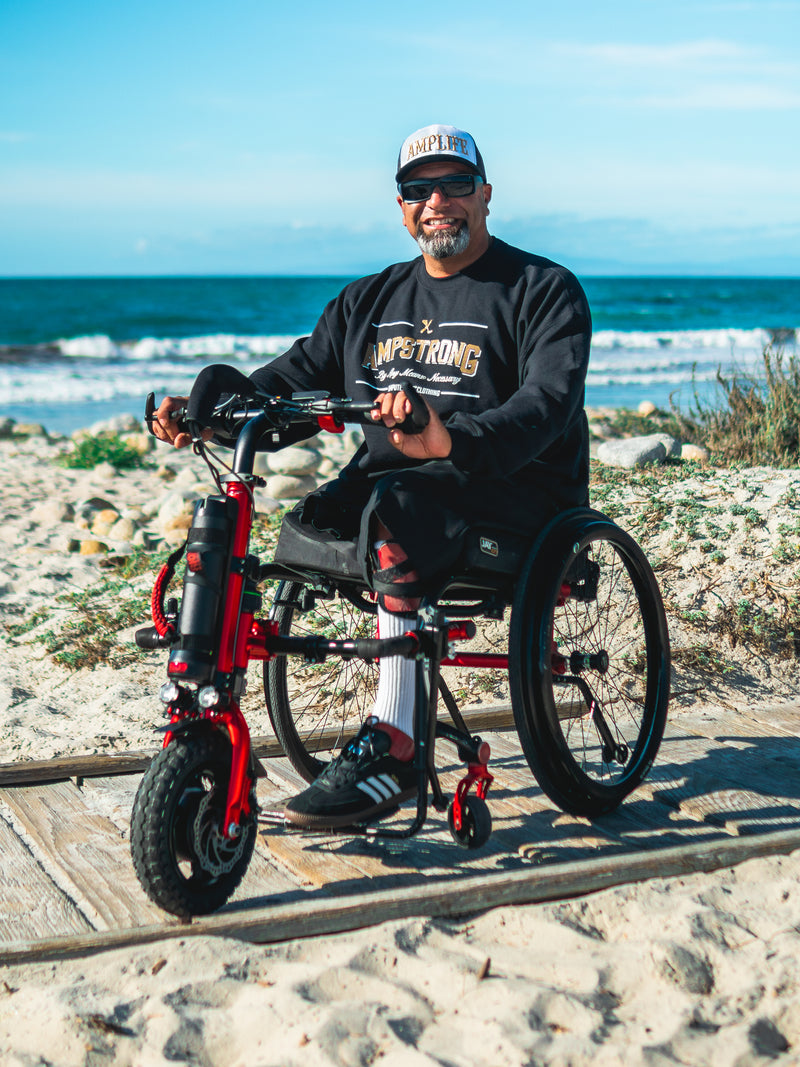 Portrait of Amplife® Foundation & Amplife® Founder Abdul Nevarez on his Rio Mobility Firefly 2.5 Electric Scooter Wheelchair Attachment at Pebble Beach