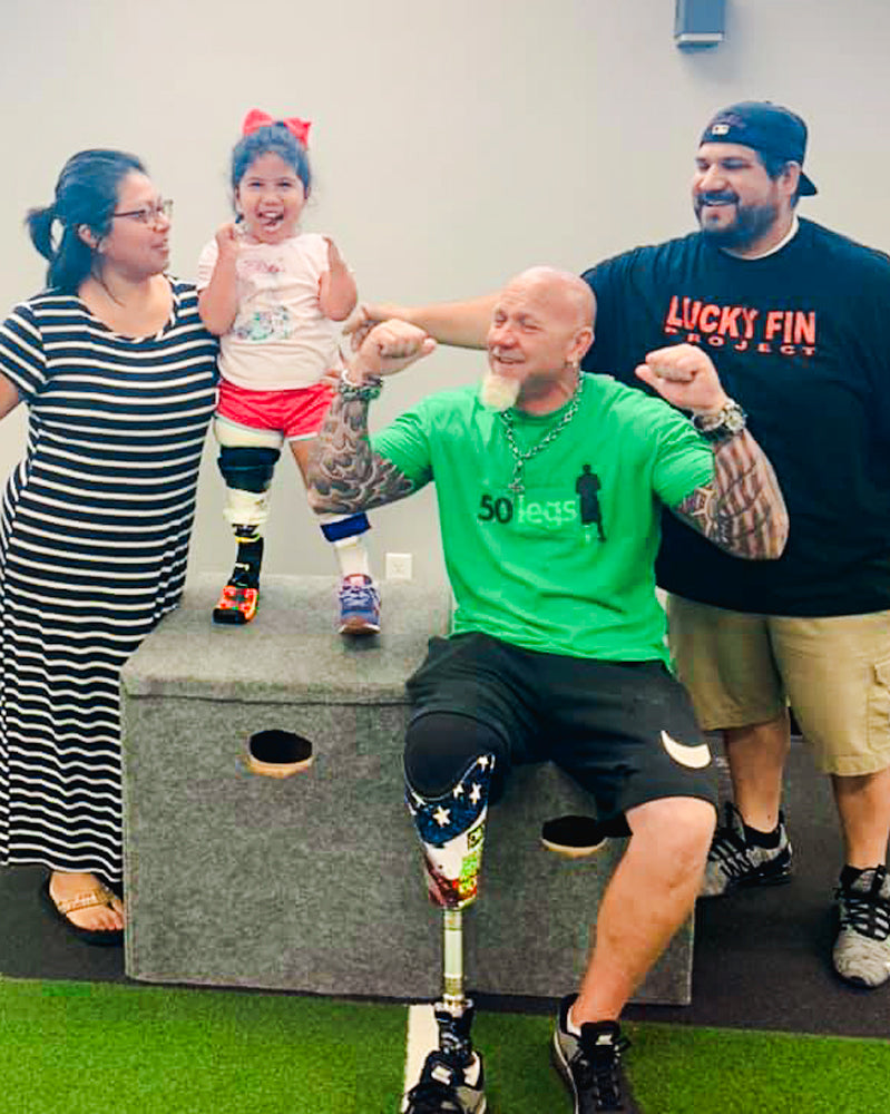 Amplife® Love Cause 50 Legs group photo of kid amputee and their parents with 50 Legs Founder Steve Chamberland