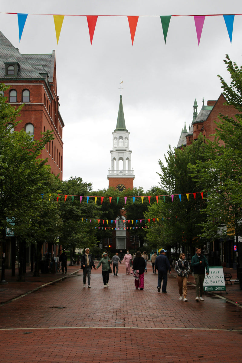 Burlington, Vermont town square with a clock tower and people walking on a snowy day