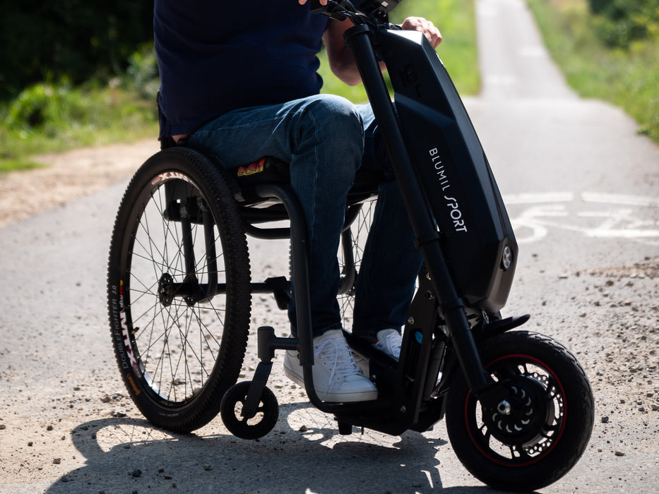 Man riding the Blumil Sport Electric Wheelchair Attachment on a road.