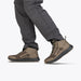 Men's Taupe BILLY Inclusion Trail Boot modeled with gray pants on a white background