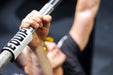 Detail of Equip Products Barbell Markers for Visually Impaired in use on a barbell as the athlete performs a bench press.