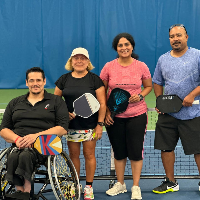 Portrait of Cincinnati Tennis Foundation Championship wheelchair and three para-standing competitors on the court with their pickleball paddles with their pickleball paddles.