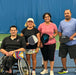 Portrait of Cincinnati Tennis Foundation Championship wheelchair and three para-standing competitors on the court with their pickleball paddles with their pickleball paddles.