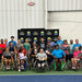 Group of Cincinnati Tennis Foundation Championship competitors in front of a banner of Cincinnati Tennis Foundation logos.