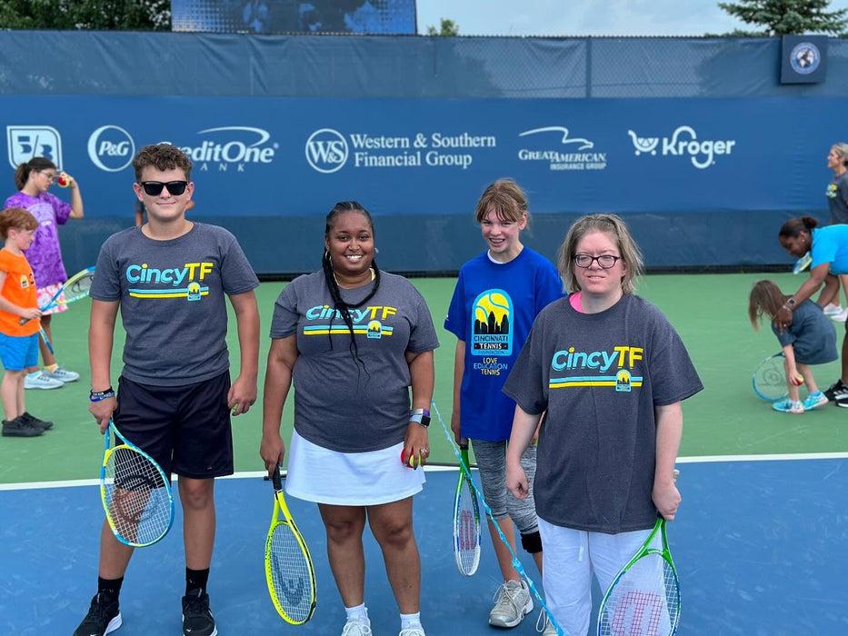 Group of people on a tennis court wearing CincyTF shirts.