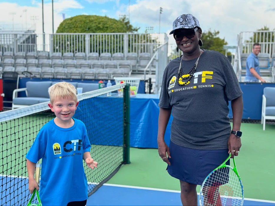 Woman and child from Cincinnati Tennis Foundation on a tennis court.