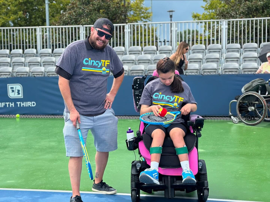 Father and child from Cincinnati Tennis Foundation on a tennis court.