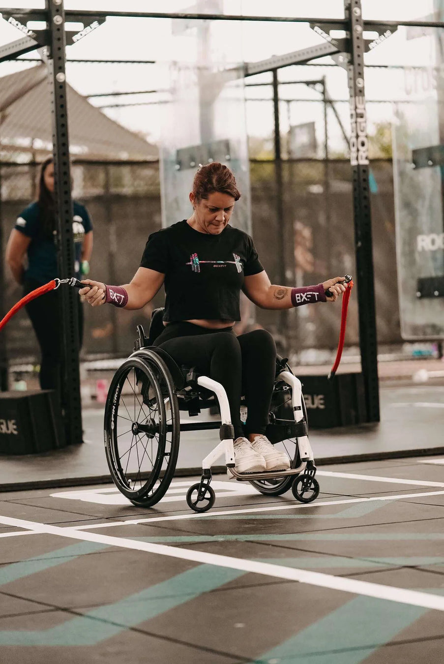 An athlete using a wheelchair with their Multi Ropes™ in a gym.