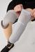 A close-up of a person putting on above their knee the Ethnocare Underlay Transtibial Closed Prosthetic Sweat Management Device around their residual limb. 