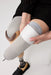 A close-up of a person finishing putting on liner with the Ethnocare Underlay Transtibial Closed Prosthetic Sweat Management Device underneath. 
