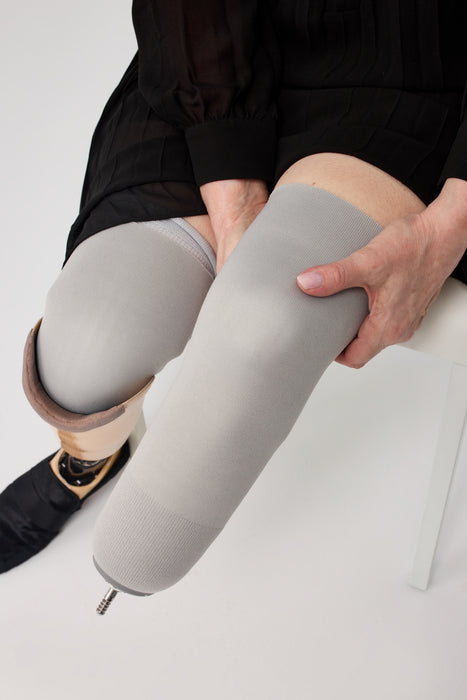 A close-up of a person with a liner on with the Ethnocare Underlay Transtibial Closed Prosthetic Sweat Management Device underneath