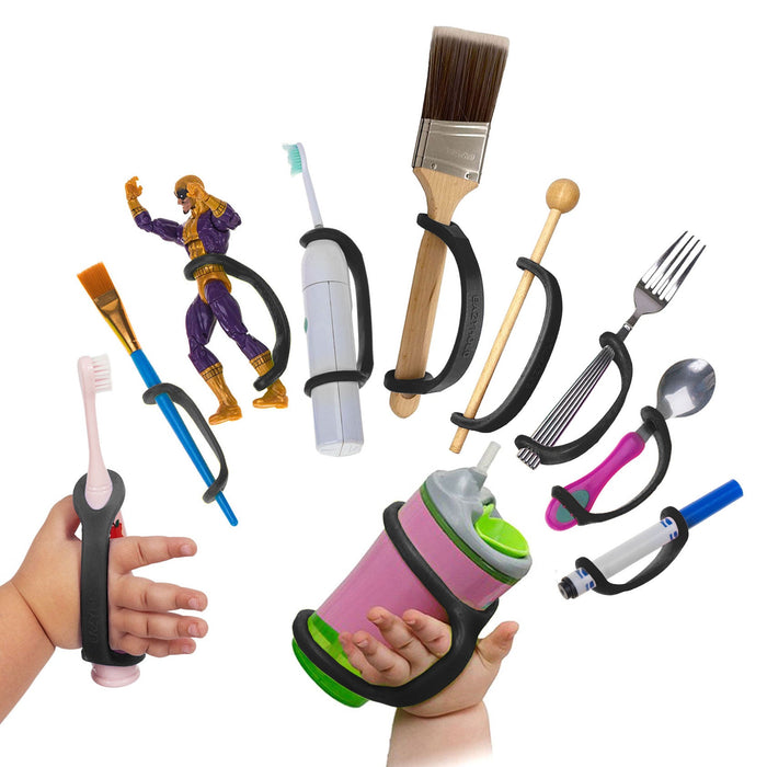 Assorted children's utensils and toys with a black EaZyHold Grip Aid on a white background