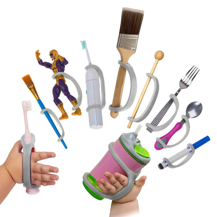 Assorted children's utensils and toys with a platinum EaZyHold Grip Aid on a white background