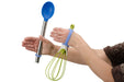 Hand holding a blue spoon and green whisk with an EaZyHold Grid Aid on a white background