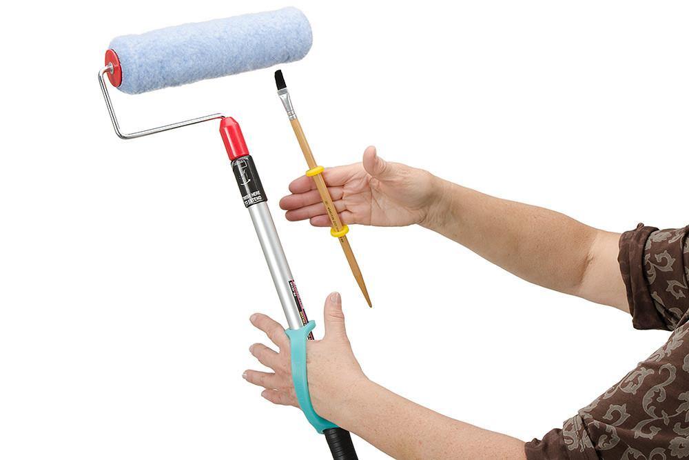 Person holding a paint roller and brush with with an aqua EaZyHold Grip Aid on a white background