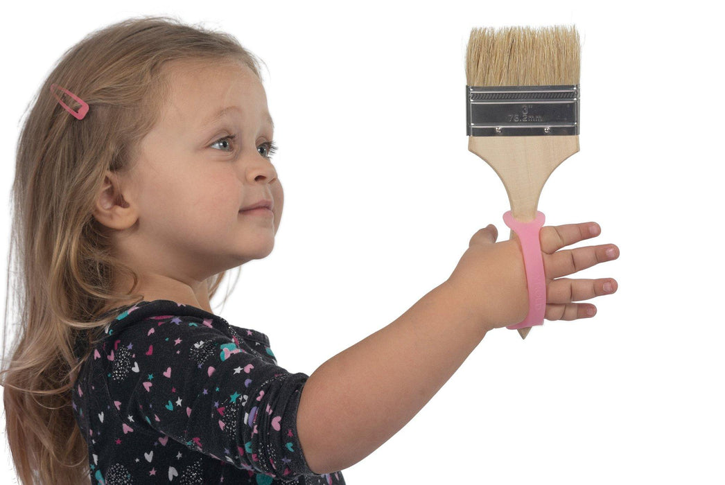 Child holding a paintbrush with a pink EaZyHold Grid Aid on a white background