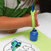 Child's hand using a paintbrush with a green EaZyHold Grip Aid to paint