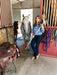Woman standing with a horse in a stable holding a broom with an aqua EaZyHold Grip Aid