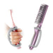 Purple comb and hand holding a pink toothbrush with a platinum EaZyHold Grid Aid on a white background