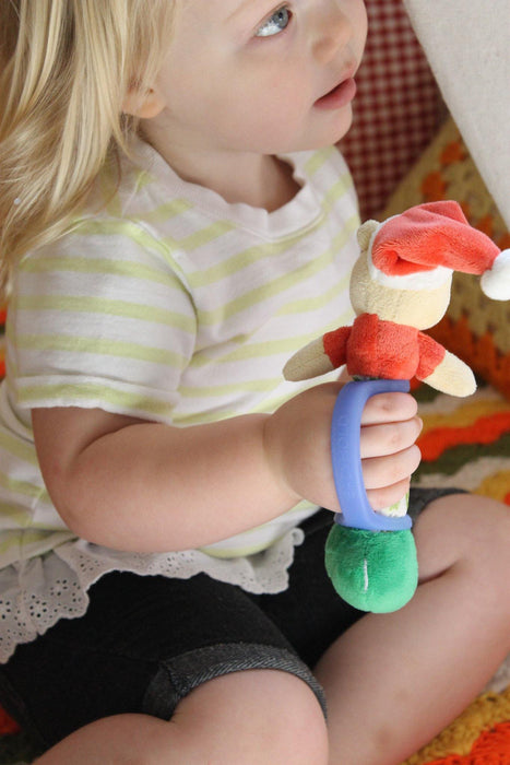 Child holding a colorful toy with a blue EaZyHold Grid Aid in the background
