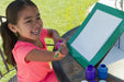 Young girl writing on a portable whiteboard outdoors with an orange EaZyHold Grid Aid