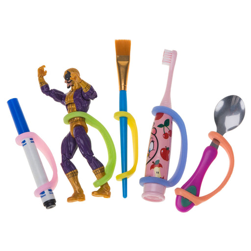 Colorful children's utensils and toys including a brush, action figure, toothbrush, spoon, and marker with an EaZyHold Grip Aid holding each item on a white background 