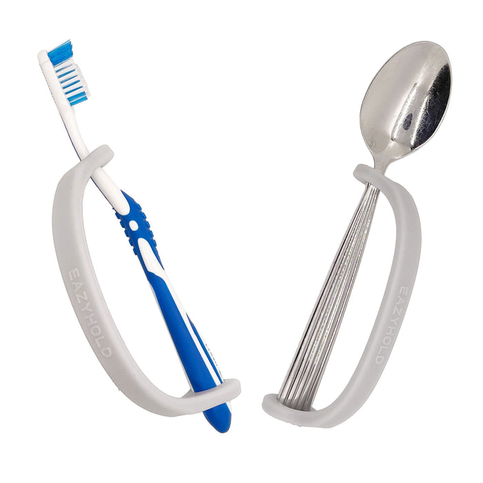 Silver spoon and toother brush with a silver EaZy Hold Grip Aid on a white background