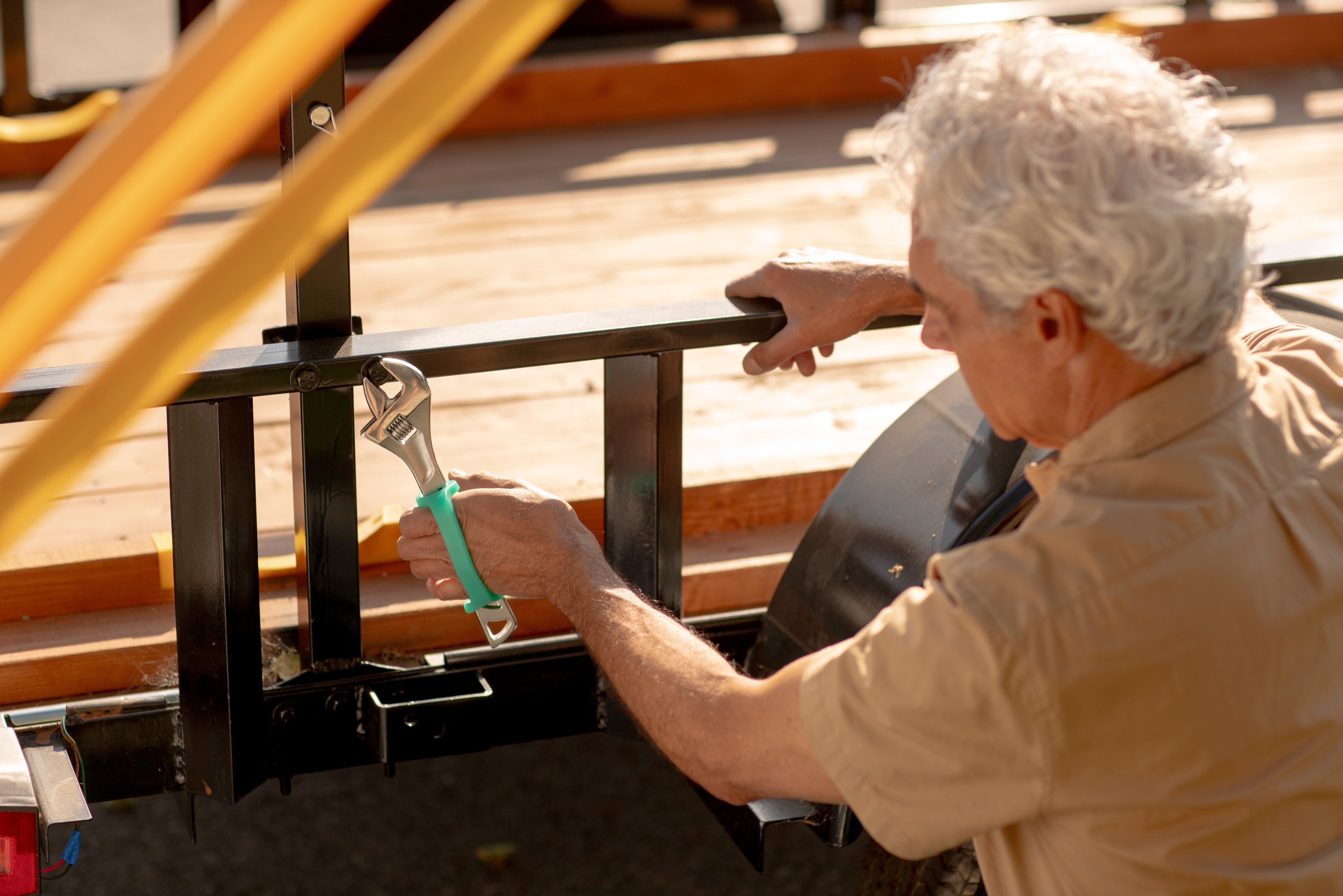 Person using a wrench with an EaZyHold on a metal structure outdoors