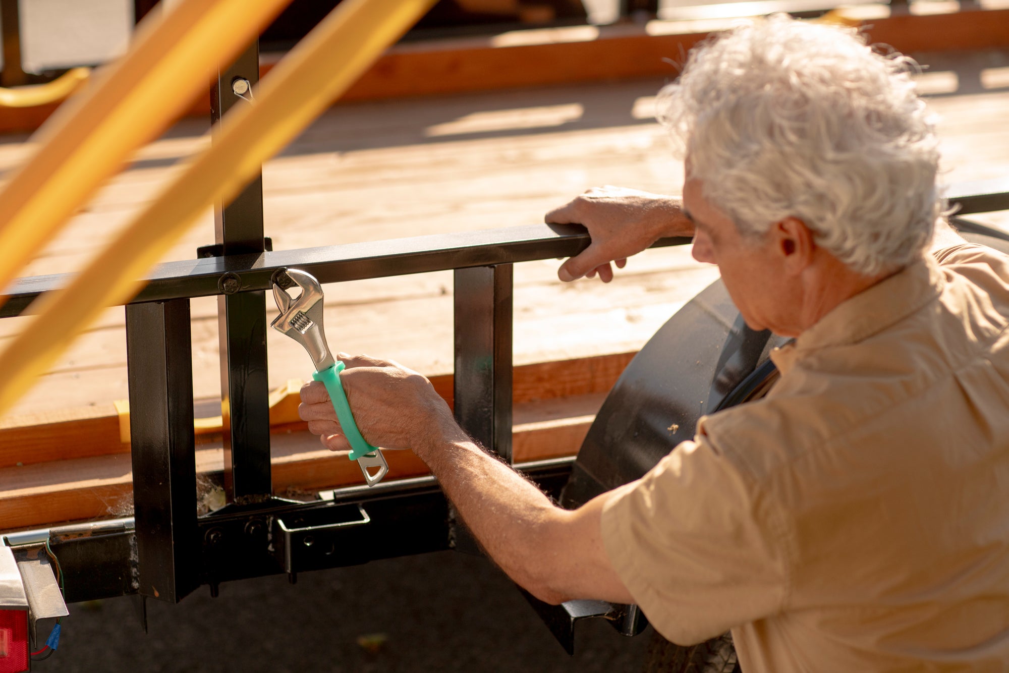 Person using a wrench with an EaZyHold on a metal structure outdoors