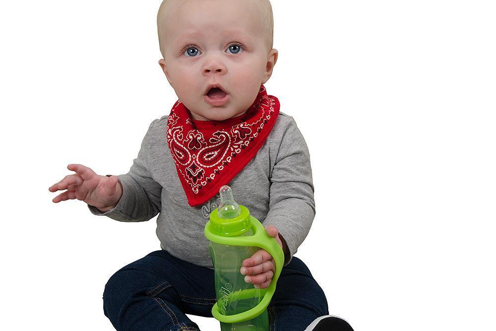 Baby holding a green sippy cup with a lime green EaZyHold Grip Aid on a white background