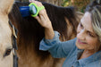 Woman brushing a horse's mane with with a lime green EaZyHold Grip Aid
