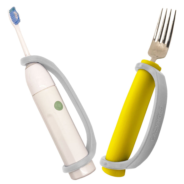 White electric toothbrush and yellow fork with a platinum EaZyHold Grip Aid on a white background